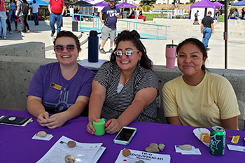 San Juan College Employees at table for outdoor event.